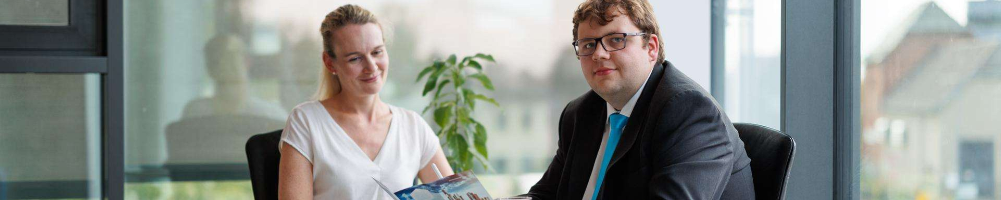 Managed-Services-Hero Managed Services Hero Image – Zwei Personen an einem Tisch: links eine Kundin, rechts ein Mitarbeiter mit Broschüre, der professionelle Beratung und Serviceleistungen im Bereich Managed Services vermittelt.