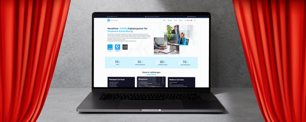 HexaMain neue Website Blog – Ein Laptop zeigt die neue HexaMain Website, während sich im Hintergrund Kino-Vorhänge öffnen und den Eindruck einer exklusiven Premiere vermitteln.